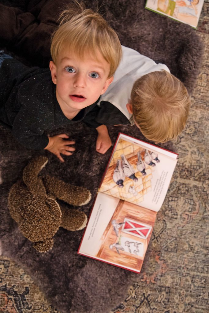 A blue-eyed child looking up from book