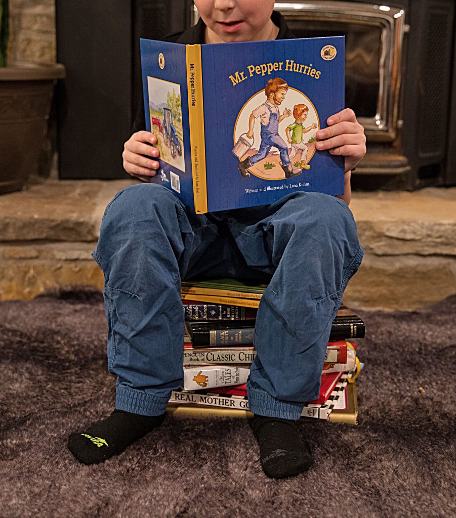 Boy sitting on stack of books