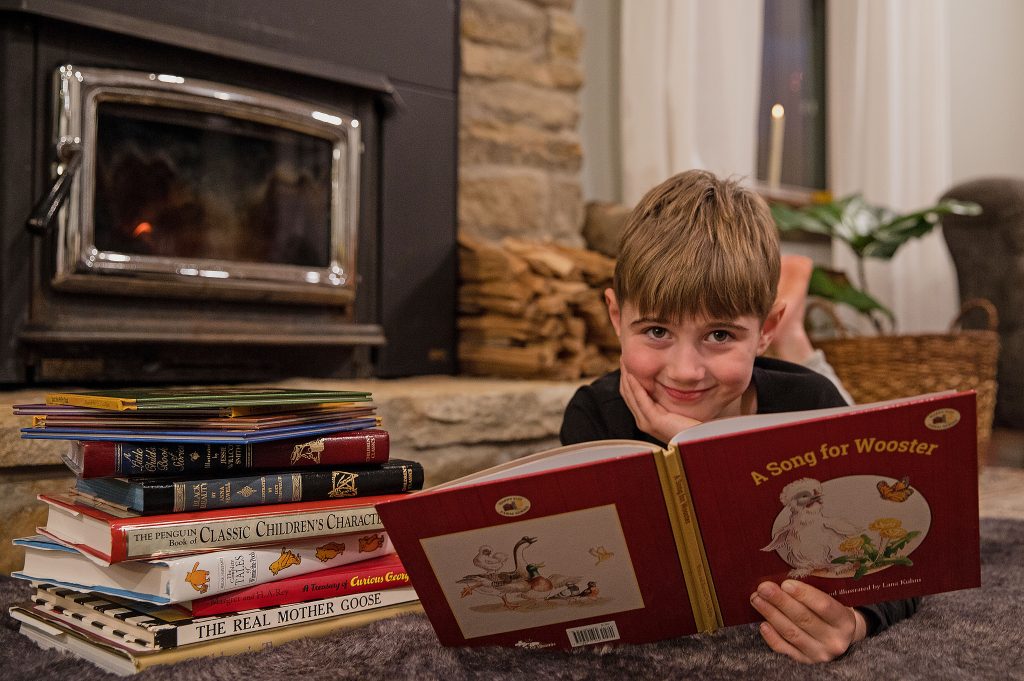 Little boy on tummy reading book