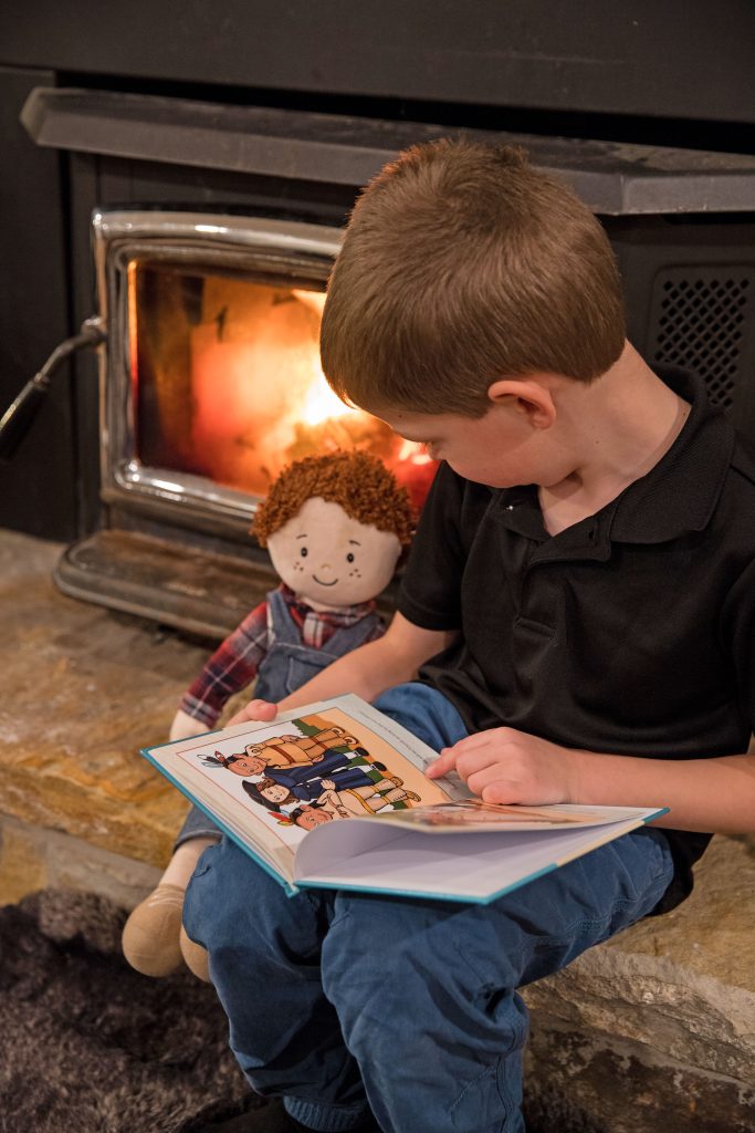 Little boy talking to doll