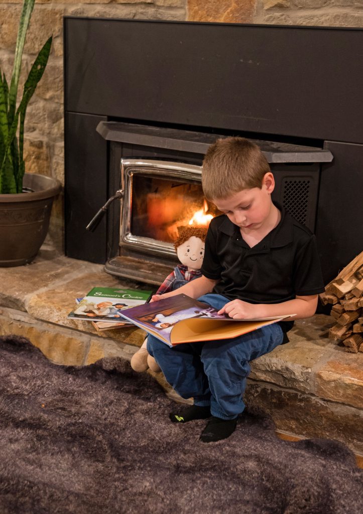 looking at book in Front of Fireplace